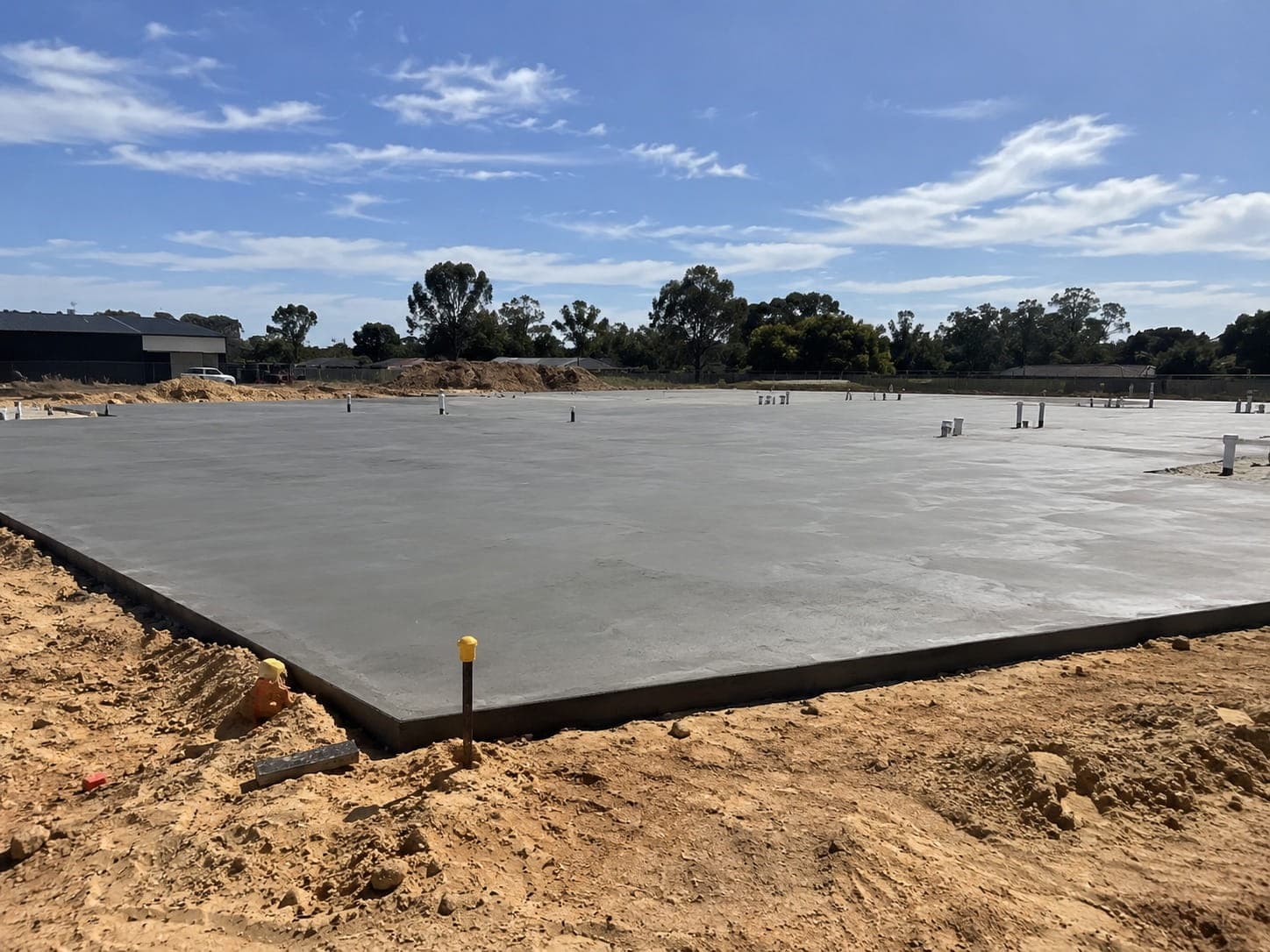 Large finished slab with service risers standing, edged against sand