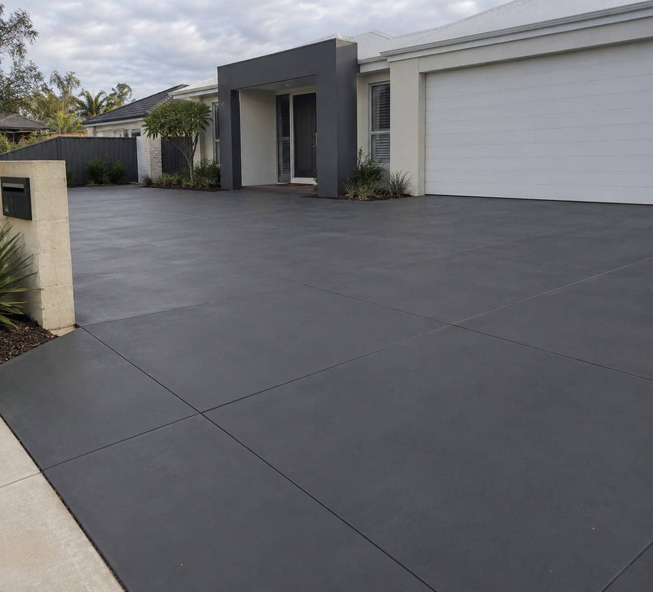 Coloured concrete driveway in a warm oxide tone at a Mandurah property