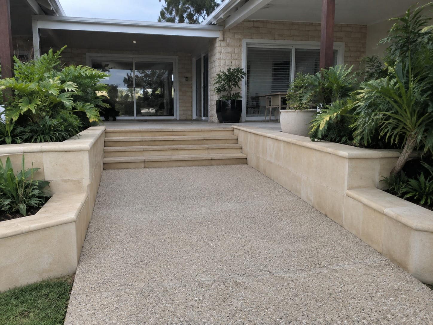Exposed aggregate pathway between limestone garden walls