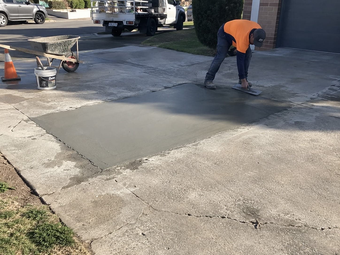 Concreter trowelling a repair section into a cracked driveway