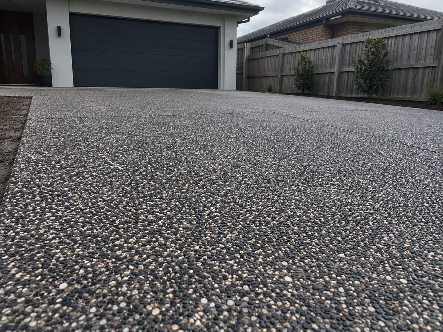Charcoal and tan exposed aggregate driveway running up to a garage in Mandurah