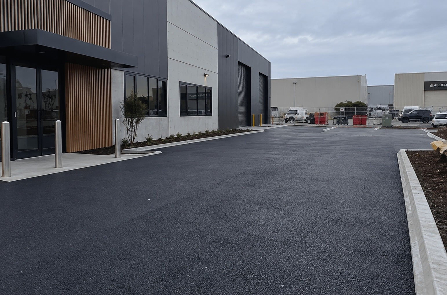 Dark open-graded permeable pavement across a forecourt at a Mandurah commercial building