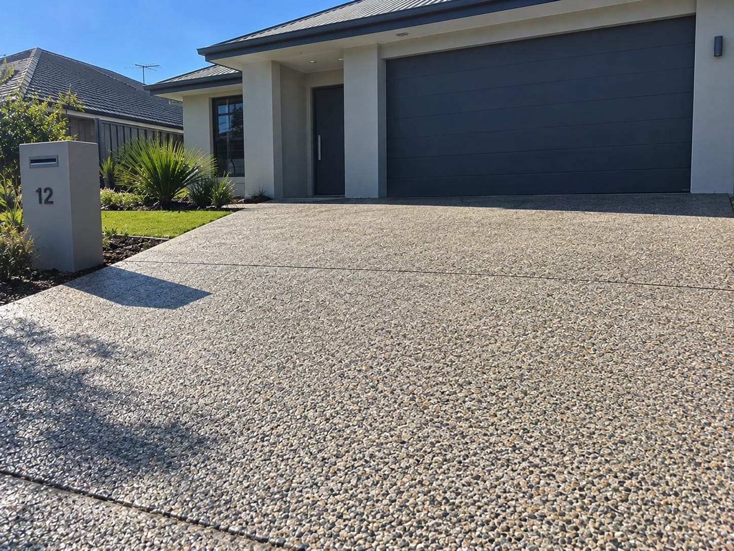 Textured pebble-finish driveway running up to the garage of a Mandurah home