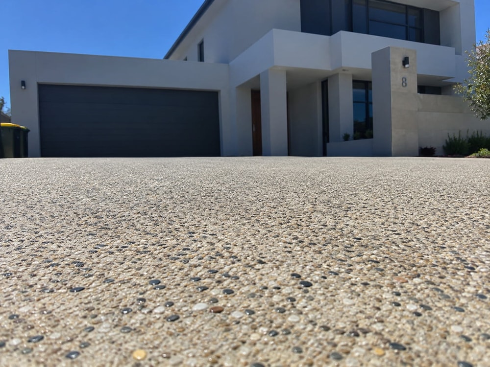 Honey-toned exposed aggregate driveway after resealing, with the stone colour brought back up
